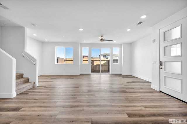 unfurnished living room featuring ceiling fan and light hardwood / wood-style flooring