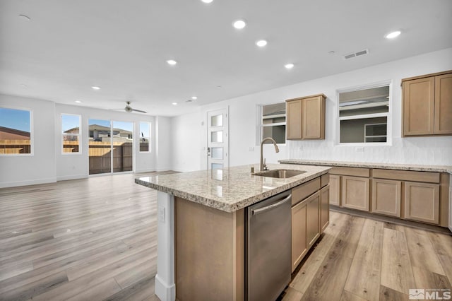 kitchen with sink, a center island with sink, dishwasher, light stone countertops, and light hardwood / wood-style floors