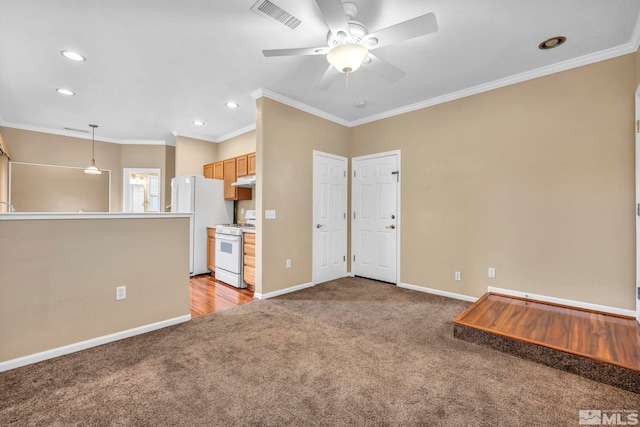 unfurnished living room featuring ceiling fan, ornamental molding, and light carpet