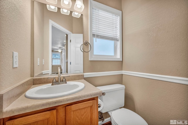 bathroom featuring vanity, toilet, and a wealth of natural light