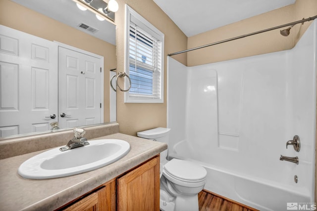 full bathroom featuring vanity, hardwood / wood-style flooring, toilet, and tub / shower combination