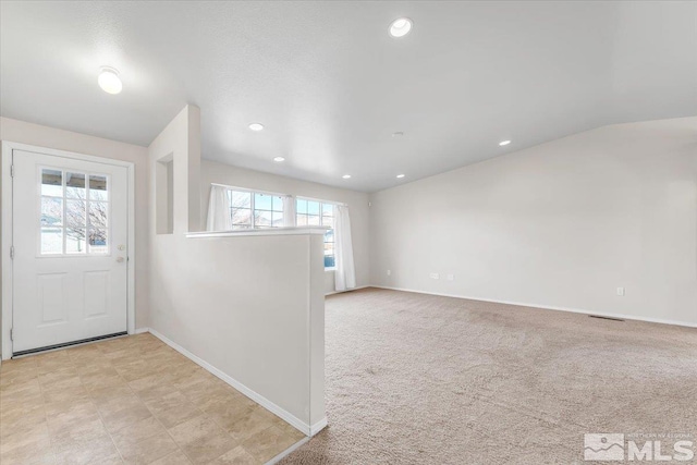 carpeted foyer entrance with lofted ceiling