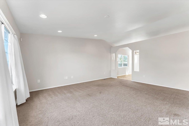 unfurnished room with light carpet and vaulted ceiling