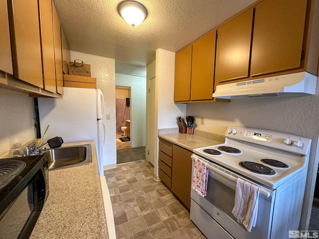 kitchen featuring a textured ceiling, sink, and white appliances