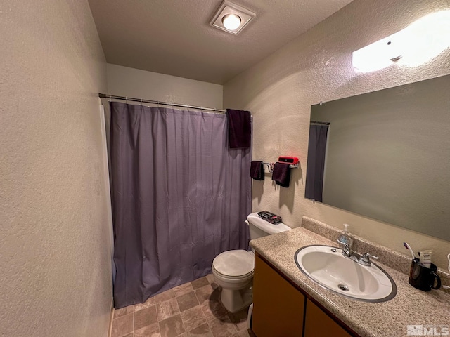 bathroom with walk in shower, vanity, a textured ceiling, and toilet