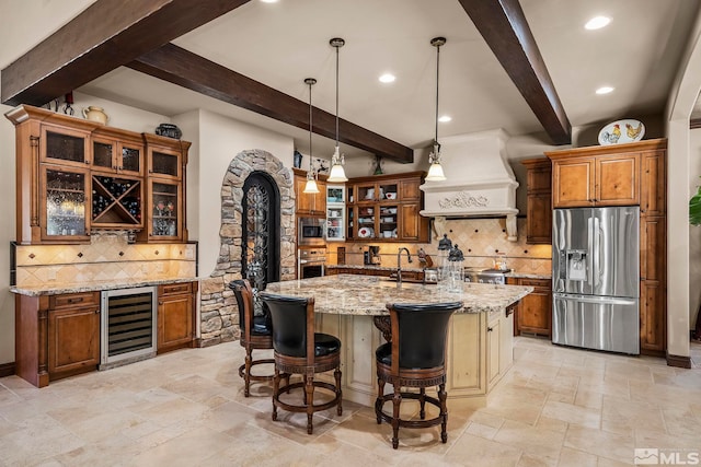 kitchen featuring light stone countertops, stainless steel appliances, wine cooler, premium range hood, and a kitchen bar