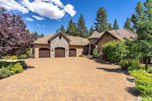 french country inspired facade featuring a garage