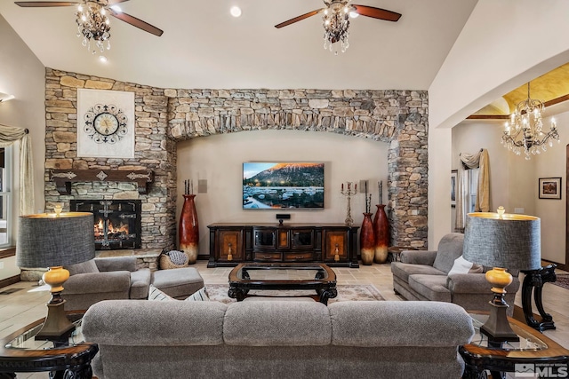 living room with a fireplace, ceiling fan with notable chandelier, and vaulted ceiling