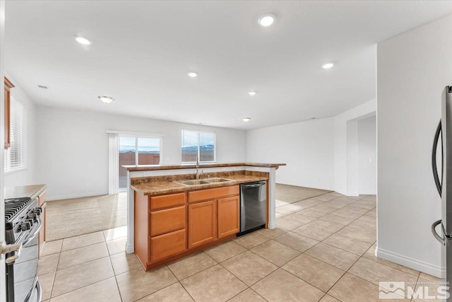 kitchen with light stone countertops, sink, stainless steel appliances, a center island with sink, and light tile patterned floors