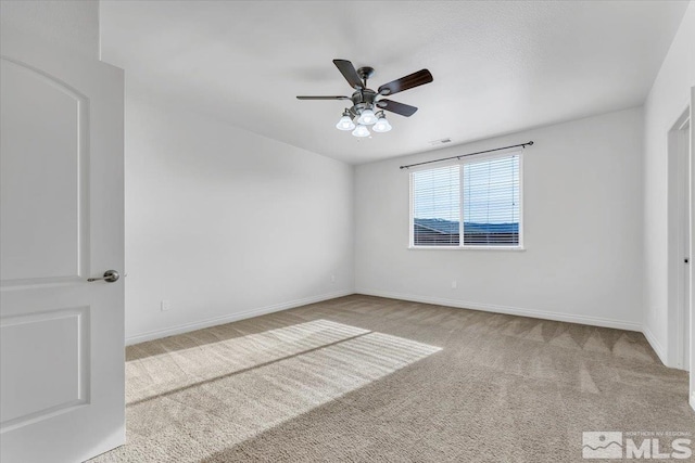 spare room featuring light carpet and ceiling fan