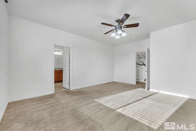 unfurnished bedroom featuring light carpet, connected bathroom, and ceiling fan