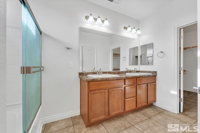 bathroom featuring tile patterned flooring, vanity, and enclosed tub / shower combo