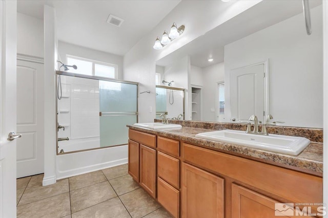 bathroom featuring tile patterned flooring, vanity, and combined bath / shower with glass door