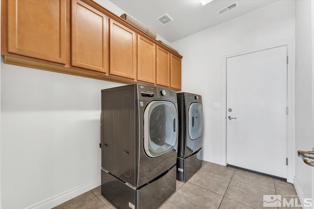 laundry area with cabinets, independent washer and dryer, and light tile patterned flooring