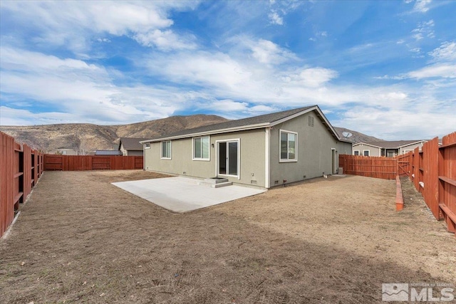 back of property featuring a mountain view and a patio area