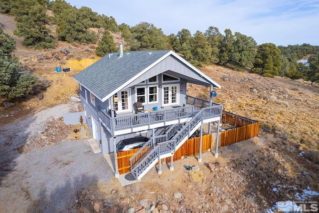 back of house with a garage and a deck