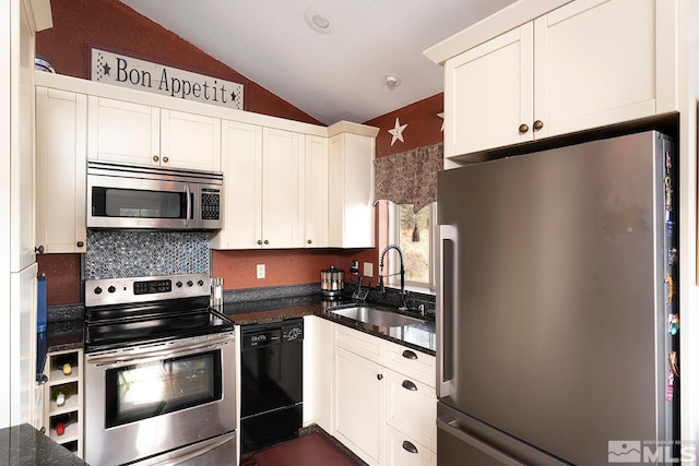 kitchen featuring white cabinetry, sink, stainless steel appliances, vaulted ceiling, and decorative backsplash