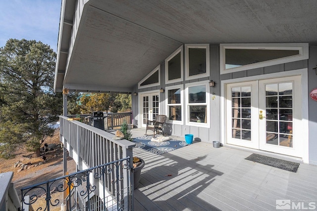 wooden deck with a grill and french doors