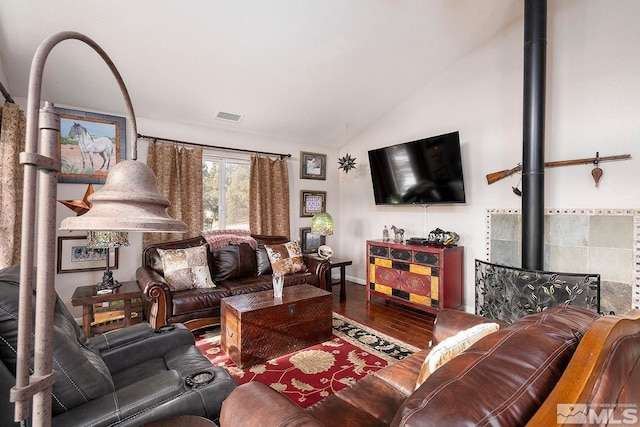 living room featuring wood-type flooring, a wood stove, and lofted ceiling