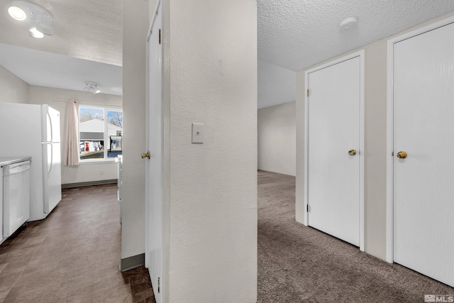 hall with carpet flooring and a textured ceiling