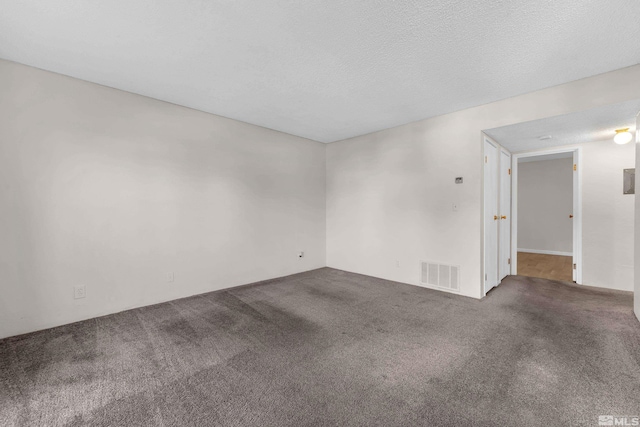 carpeted spare room with a textured ceiling