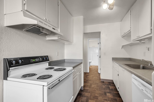 kitchen with white appliances, white cabinetry, and sink