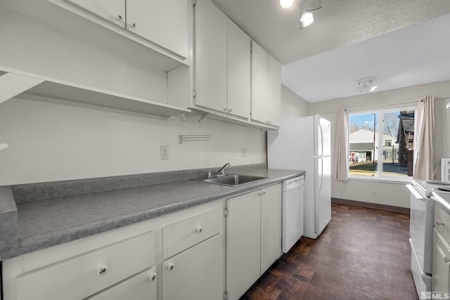 kitchen with white appliances, white cabinetry, and sink