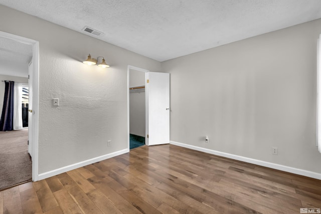 spare room with wood-type flooring and a textured ceiling