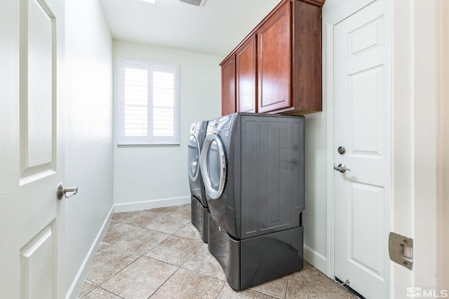 clothes washing area featuring light tile patterned flooring, cabinets, and washing machine and clothes dryer