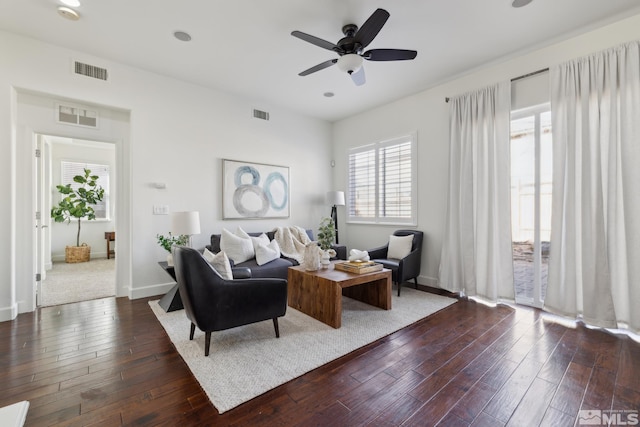 living room featuring ceiling fan and dark hardwood / wood-style floors