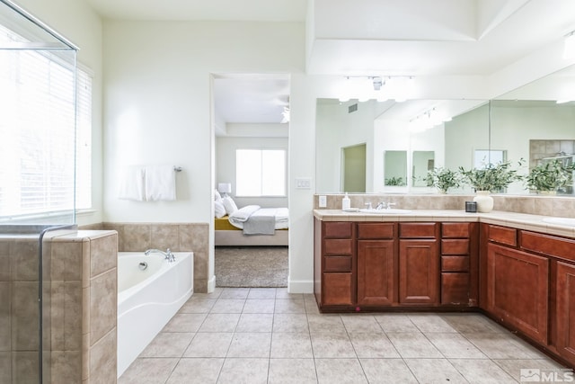 bathroom with tile patterned flooring, a healthy amount of sunlight, and a tub