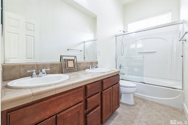 full bathroom with vanity, shower / bath combination with glass door, tile patterned floors, toilet, and tasteful backsplash