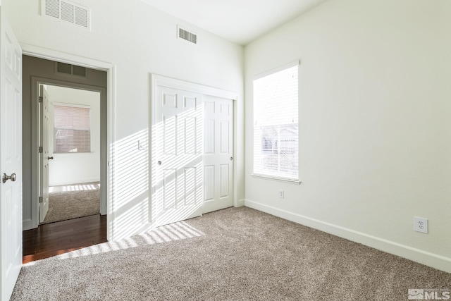 unfurnished bedroom with multiple windows, a closet, and carpet