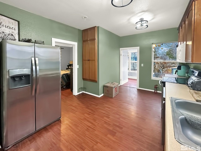 kitchen with stainless steel fridge with ice dispenser, sink, dark hardwood / wood-style floors, and range