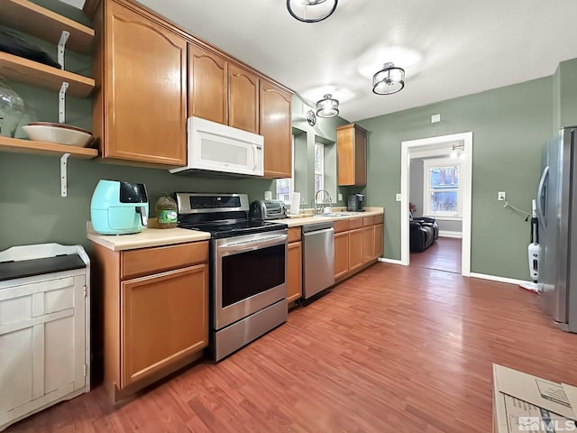 kitchen featuring sink, light wood-type flooring, and appliances with stainless steel finishes