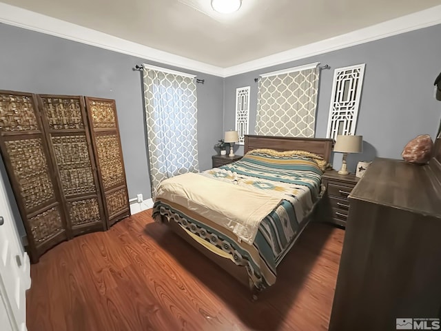 bedroom with wood-type flooring and ornamental molding