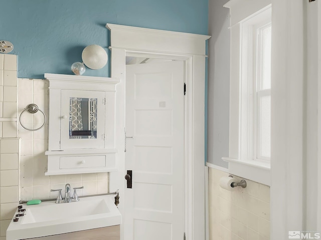 bathroom with backsplash, plenty of natural light, vanity, and tile walls