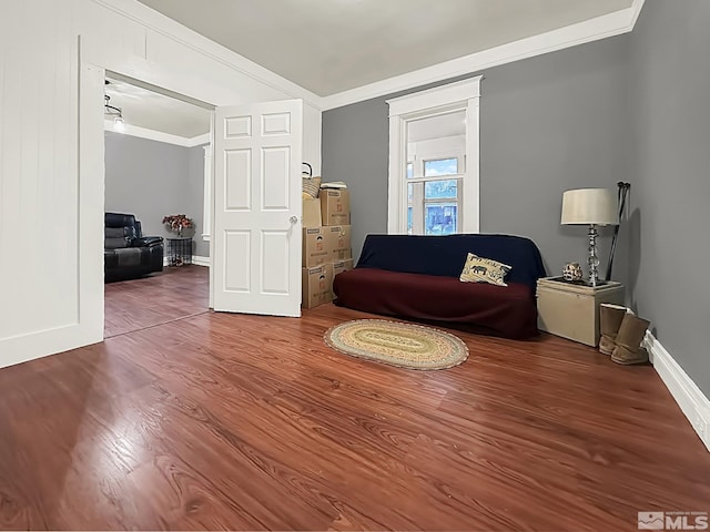 sitting room with hardwood / wood-style floors and crown molding