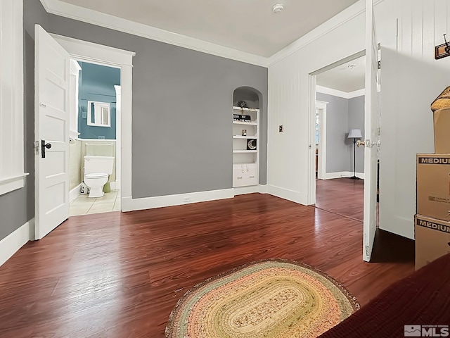 foyer entrance with crown molding and hardwood / wood-style flooring