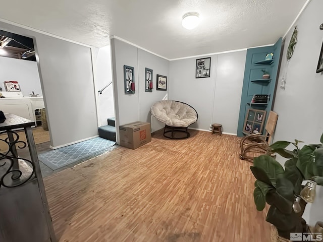 sitting room with sink, independent washer and dryer, a textured ceiling, and hardwood / wood-style floors