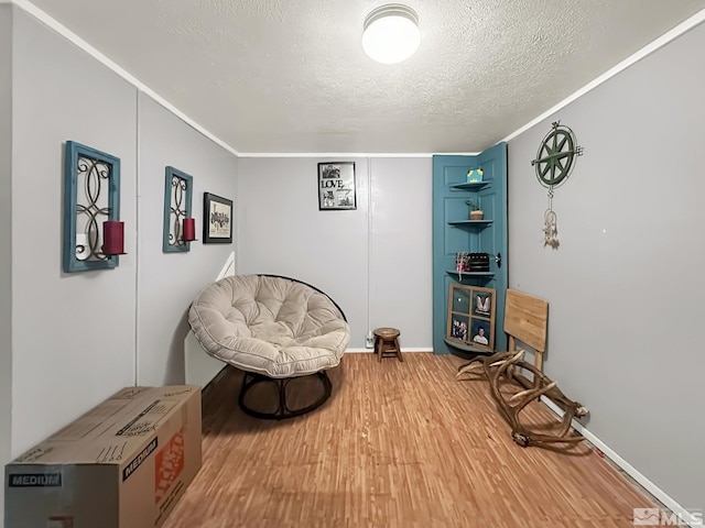 living area with a textured ceiling and hardwood / wood-style flooring