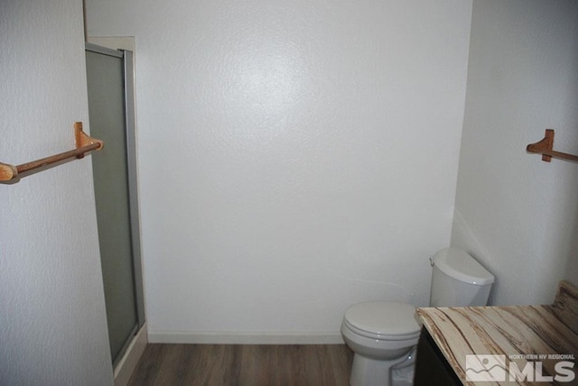 bathroom with toilet, walk in shower, and hardwood / wood-style floors