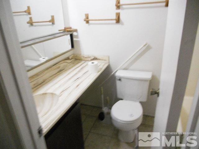 bathroom featuring toilet, vanity, and tile patterned floors