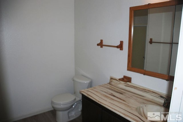 bathroom featuring toilet, hardwood / wood-style flooring, and vanity