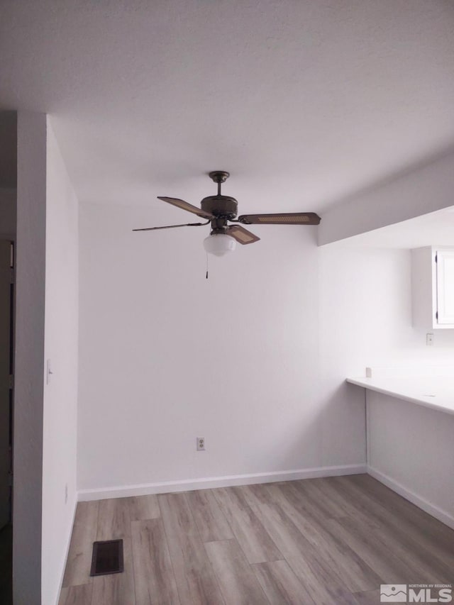 empty room with light wood-type flooring and ceiling fan