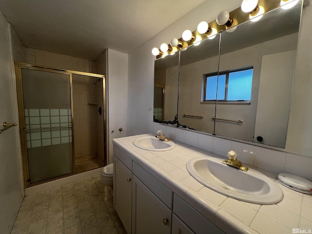 bathroom with vanity, toilet, walk in shower, and backsplash