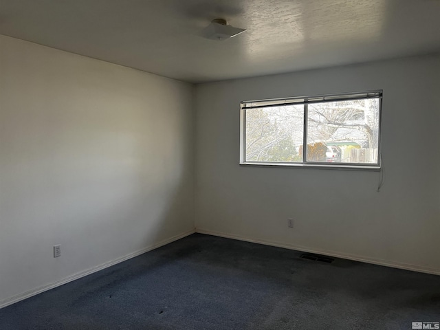 carpeted spare room with a textured ceiling