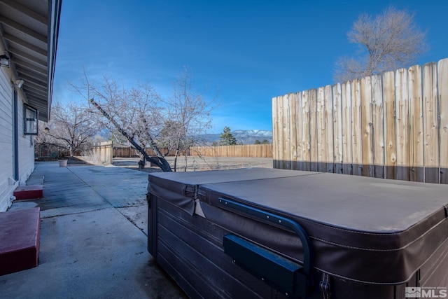 view of patio featuring a mountain view and a hot tub