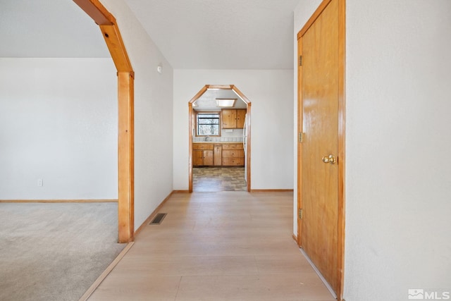 hall with light hardwood / wood-style floors and sink