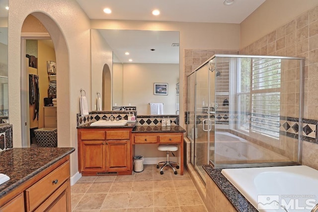 bathroom with plus walk in shower, tile patterned flooring, and vanity